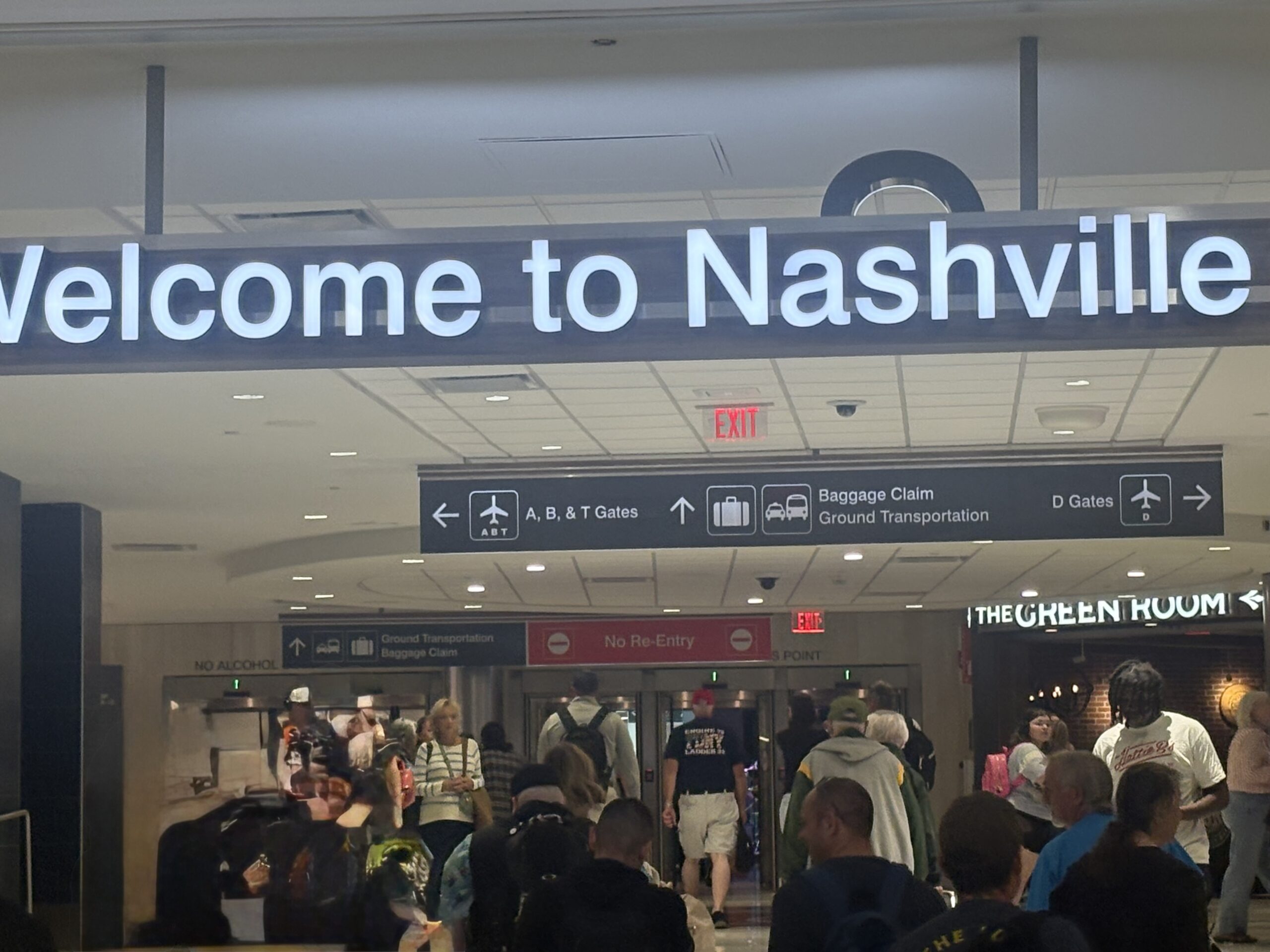 Welcome to Nashville sign in the arrivals area at Nashville International Airport, with signs pointing to baggage claim, ground transportation and gates