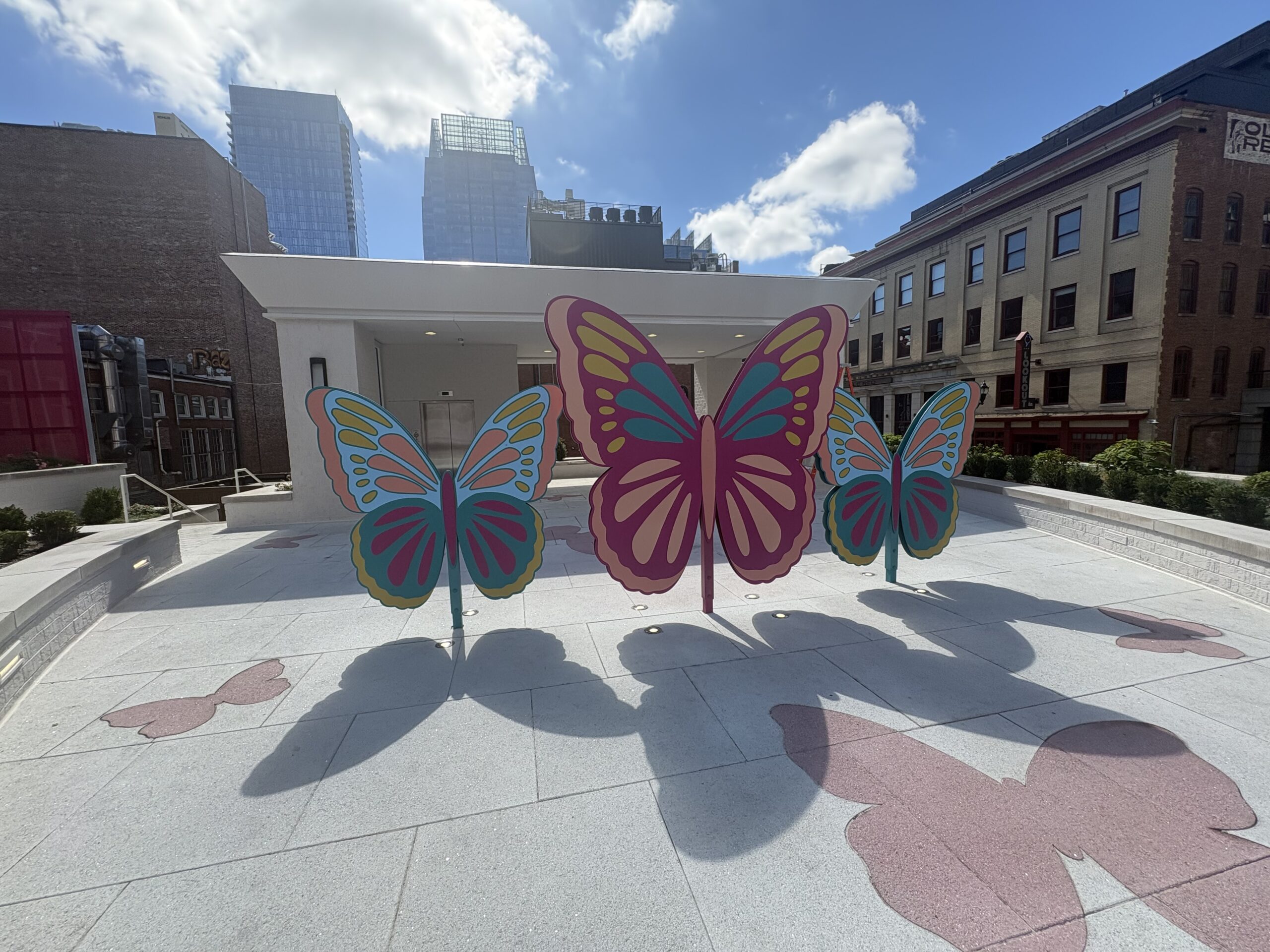 Three giant colorful butterfly sculptures on the outdoor plaza beside the Dolly's Life of Many Colors Museum entrance in downtown Nashville